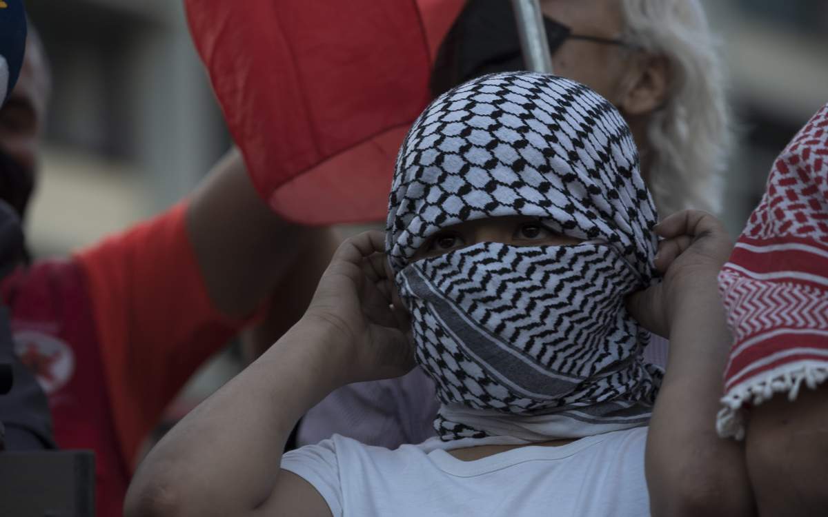 Child wears Palestinian keffiyeh