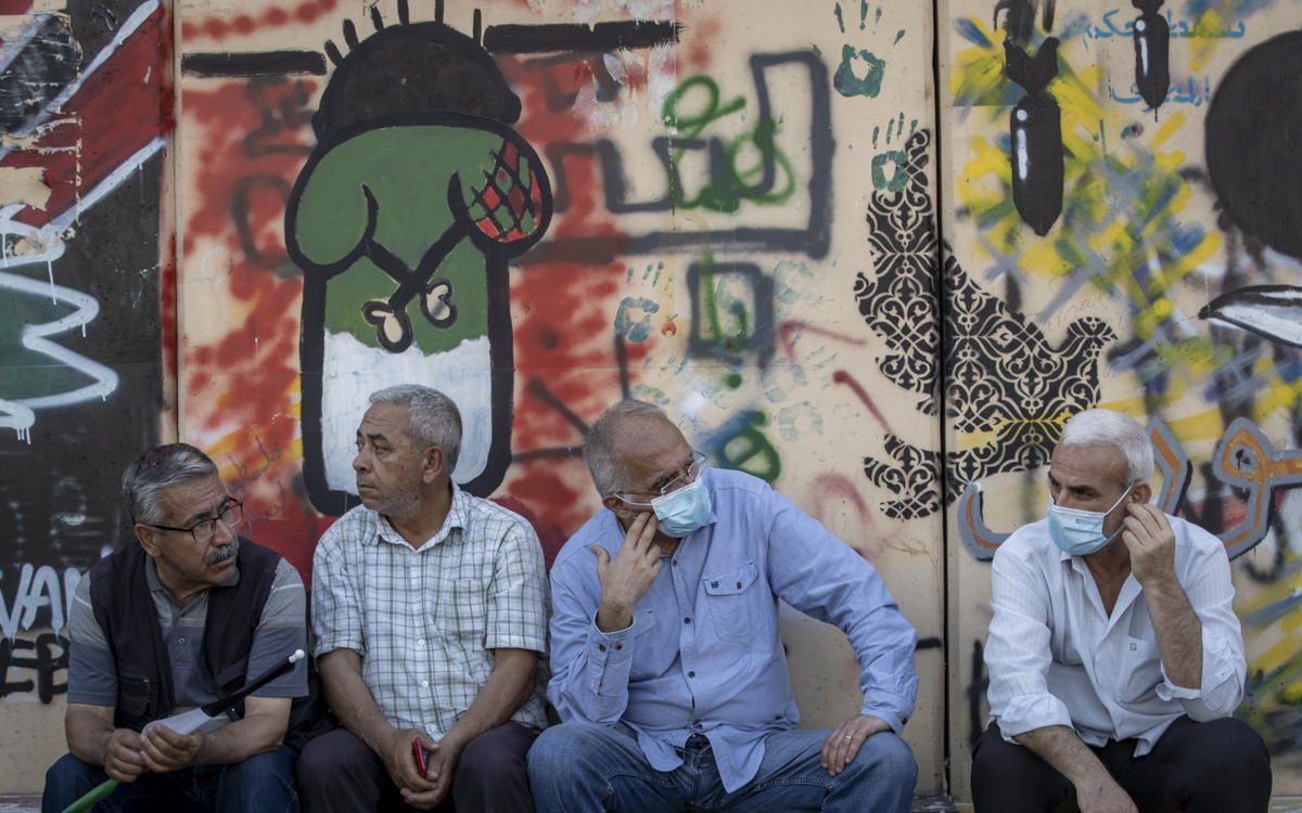 Palestinians seated in front of BDS logo in Beirut